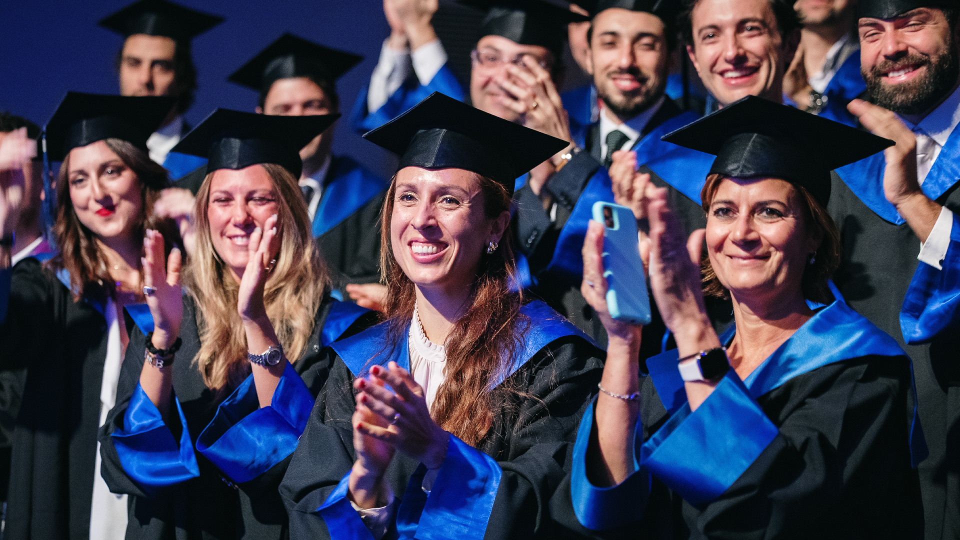 Studentesse e studenti con la toga che applaudono